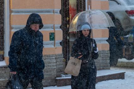 Санкт-Петербург. Женщина под зонтом на заснеженной улице.