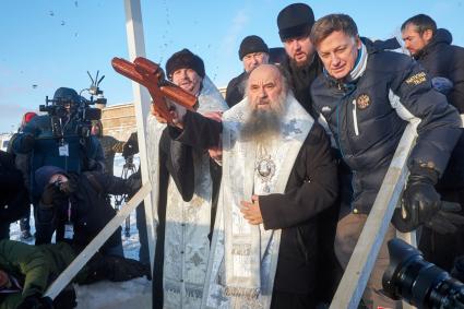 Санкт-Петербург. Священник православным крестом освящает воду перед крещенскими купаниями в праздник Крещения Господня.