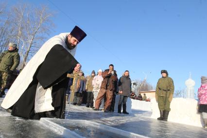 Иркутск. Священник православным крестом освящает воду перед крещенскими купаниями в праздник Крещения Господня.