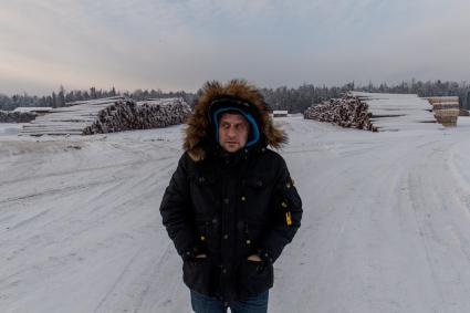 Красноярский край. Корреспондент `Комсомольской правды` Владимир Ворсобин на фоне зимней дороги (зимник) в тайге в Богучанском районе Красноярского края.