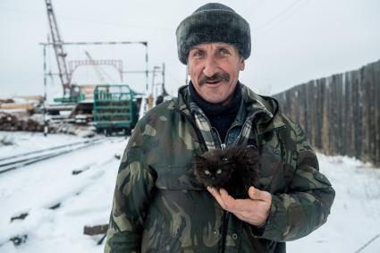 Красноярский край. Рабочий на частной китайской  лесопилке на территории принадлежащей предприятию Карабула Лес.