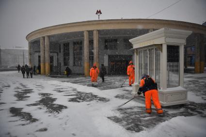 Москва. Сотрудники коммунальных служб убирают снег у наземного вестибюля станции метро `Университет`.