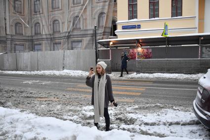 Москва.  Девушка с мобильным телефоном на Малой Никитской улице.