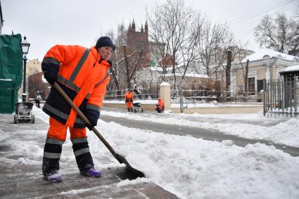 Москва.  Дворник во время уборки снега  на Малой Никитской улице.