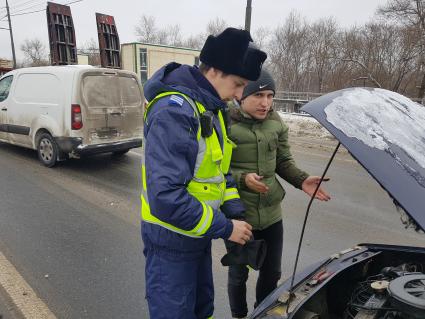 Москва. Сотрудник дорожного патруля Центра организации дорожного движения (ЦОДД) общается с водителем автомобиля на одной из улиц города.