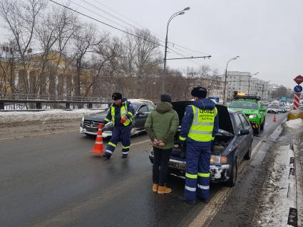 Москва. Сотрудник дорожного патруля Центра организации дорожного движения (ЦОДД) общается с водителем автомобиля на одной из улиц города.