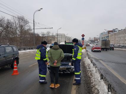 Москва. Сотрудник дорожного патруля Центра организации дорожного движения (ЦОДД) общается с водителем автомобиля на одной из улиц города.