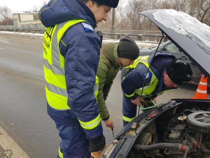 Москва. Сотрудник дорожного патруля Центра организации дорожного движения (ЦОДД) общается с водителем автомобиля на одной из улиц города.