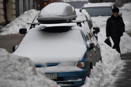 Москва. Покрытый снегом автомобиль  на одной из улиц города.