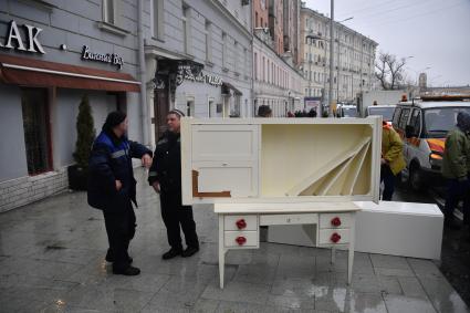 Москва. Рабочие выносят мебель из  квартир жилого дома на Никитском бульваре, где произошел пожар.