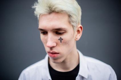 Москва. Молодой человек с татуировкой на лице.