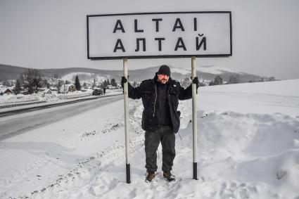 Казахстан, Алтай (Зыряновск). Корреспондент `Комсомольской правды` Дмитрий Стешин у дорожного указателя с названием города.