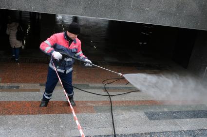 Москва. Сотрудник `Гормост`   моет кафель в подземном переходе.