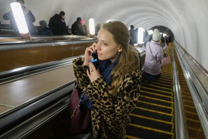 Москва.  Пассажиры на эскалаторе на одной из станций метро.