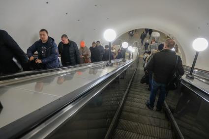 Москва.  Пассажиры на эскалаторе на одной из станций метро.