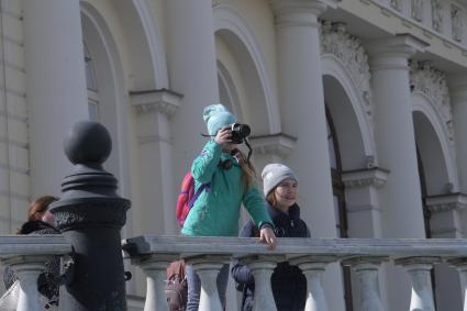 Москва. Девочка фотографирует на Манежной площади.