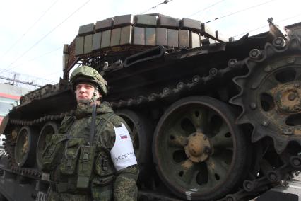 Иркутск. Военнослужащий у открытых платформ с военной техникой, которую обили у сирийских боевиков, эшелона передвижной военно-патриотической акции`Сирийский перелом` на вокзале Иркутска.