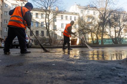 Санкт-Петербург. Сотрудники ЖКХ убирают внутридомовую территорию.