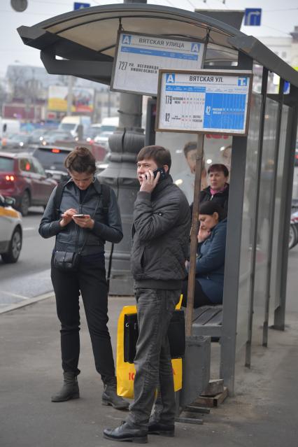 Москва.  Пассажиры на остановке общественного транспорта.