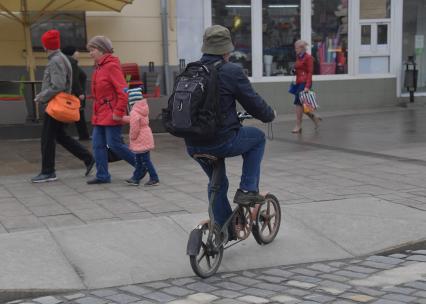 Москва.  Мужчина на велосипеде на одной из улиц города.