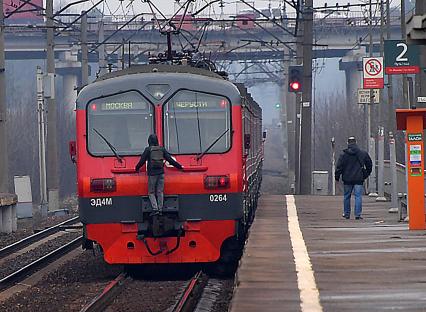 Москва.  Молодой человек `зацепер `прикрепился к последнему вагону электрички на одной из пригородных платформ.
`