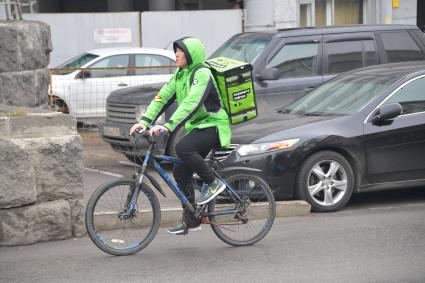 Москва.  Сотрудник сервиса по доставке еды `Деливери клаб` на одной из улиц города.