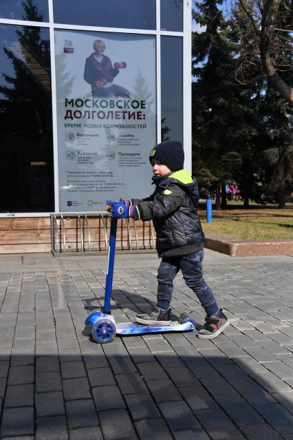 Москва.   Мальчик катается на самокате.