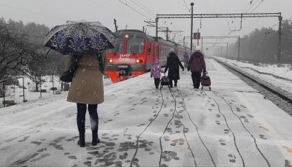 Московская область. Девушка ждет электричку на перроне во время снегопада.