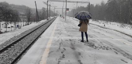 Московская область. Девушка ждет электричку на перроне во время снегопада.