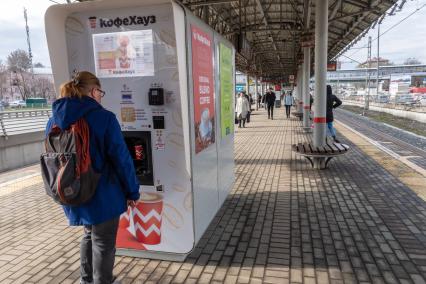 Москва. Девушка у автомата Кофе Хауз на одной из станций МЦК.