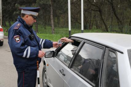 Пятигорск. Сотрудник дорожно-патрульной службы  проверяет документы у водителя.