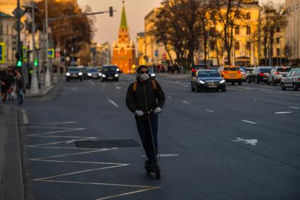 Москва.  Молодой человек на самокате  на улице Воздвиженка.