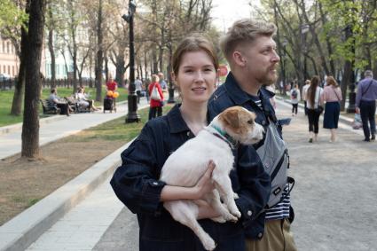 Москва.   Девушка держит на руках собаку породы фокстерьер.