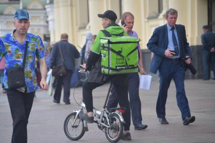 Москва. Сотрудник сервиса по доставке еды `Деливери клаб` на одной из улиц города.