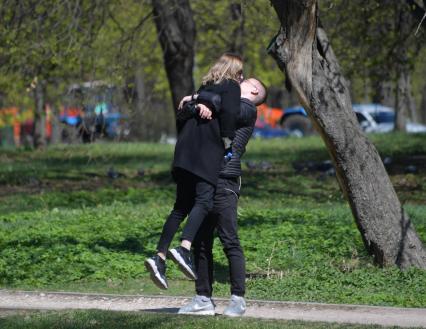 Москва. Молодые люди целуются в парке.