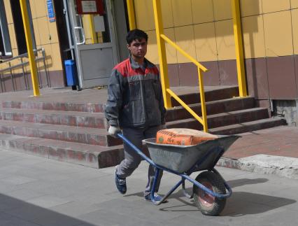 Москва.  Рабочий везет тачку.