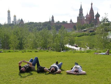 Москва. Молодые люди на газоне в парке `Зарядье`.
