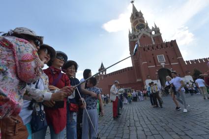 Москва.  Туристы фотографируются на Красной площади.