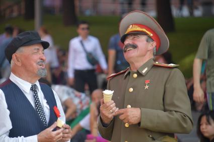 Москва.  Двойники Владимира Ленина и Иосифа Сталина на Красной площади едят мороженое.