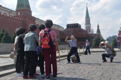 Москва.  Туристы фотографируются на Красной площади.