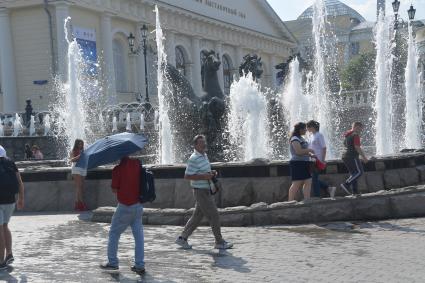 Москва.  Прохожие у фонтанов на Манежной площади.