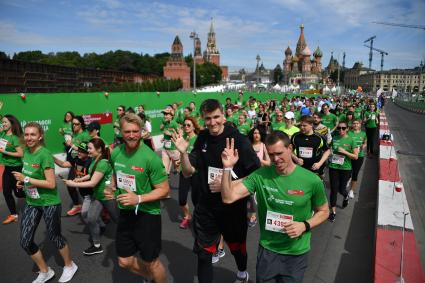 Москва.  Баскетболист Николай Падиус (третий справа) и президент Российской федерации баскетбола Андрей Кириленко (второй справа) во время благотворительного `зеленого` марафона `Бегущие сердца` на Васильевском спуске.