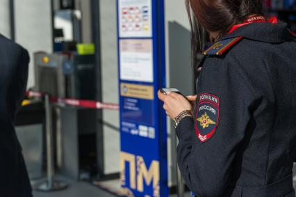Санкт-Петербург. Сотрудница полиции с мобильным телефоном во время XXIII Петербургского международного экономического форума.
