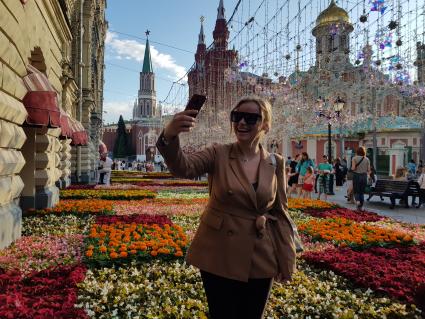 Москва. Девушка фотографируется на фестивале цветов у ГУМа.