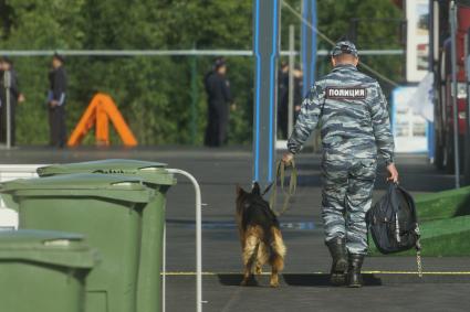 Екатеринбург. Второй день работы 10-й международной промышленной выставки \'Иннопром\'. Сотрудник полиции с служебной собакой во время к подготовки к визиту президента России Владимира Путина