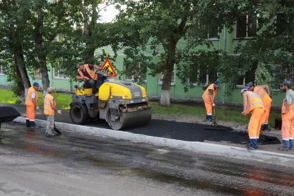 Красноярск. Рабочие укладывают асфальт.