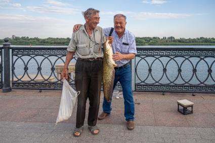 Астрахань. Корреспондент `Комсомольской правды` Александр Гамов с одним из рыбаков на центральной набережной города.