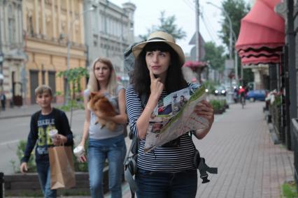Иркутск.  Девушка изучает карту на улице города.