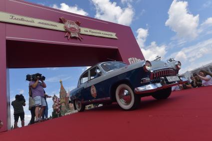 Москва. Автомобиль во время старта ежегодной гонки ретро-авто `ГУМ-авторалли` на Васильевском спуске.