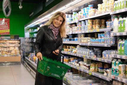 Санкт-Петербург. Женщина пенсионного возраста делает покупки в молочном отделе магазина.